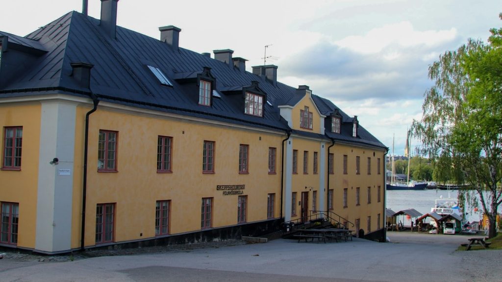 A yellow building faces the water on a cloudy day